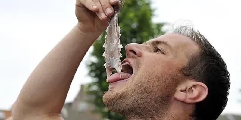 Hombre comiendo arenque holandés