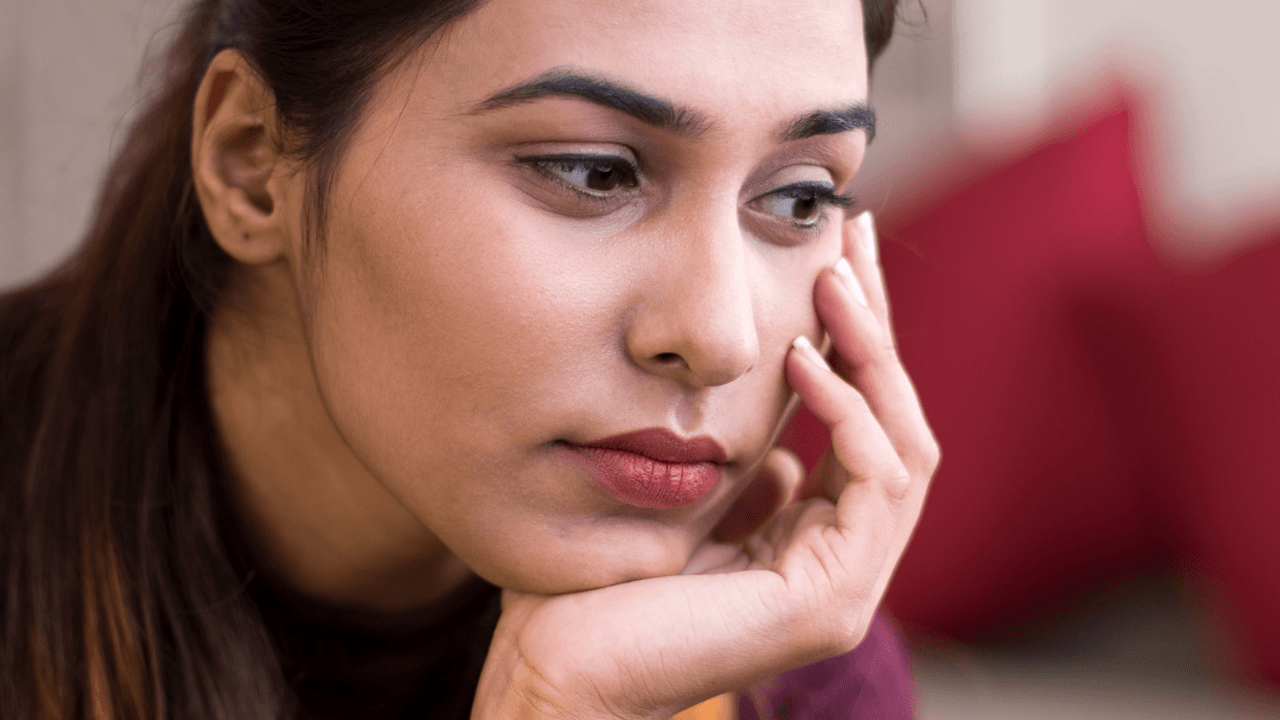 Mujer con mirada perdida sintiendose culpable por migrar