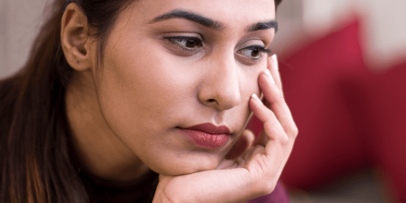 Mujer con mirada perdida sintiendose culpable por migrar