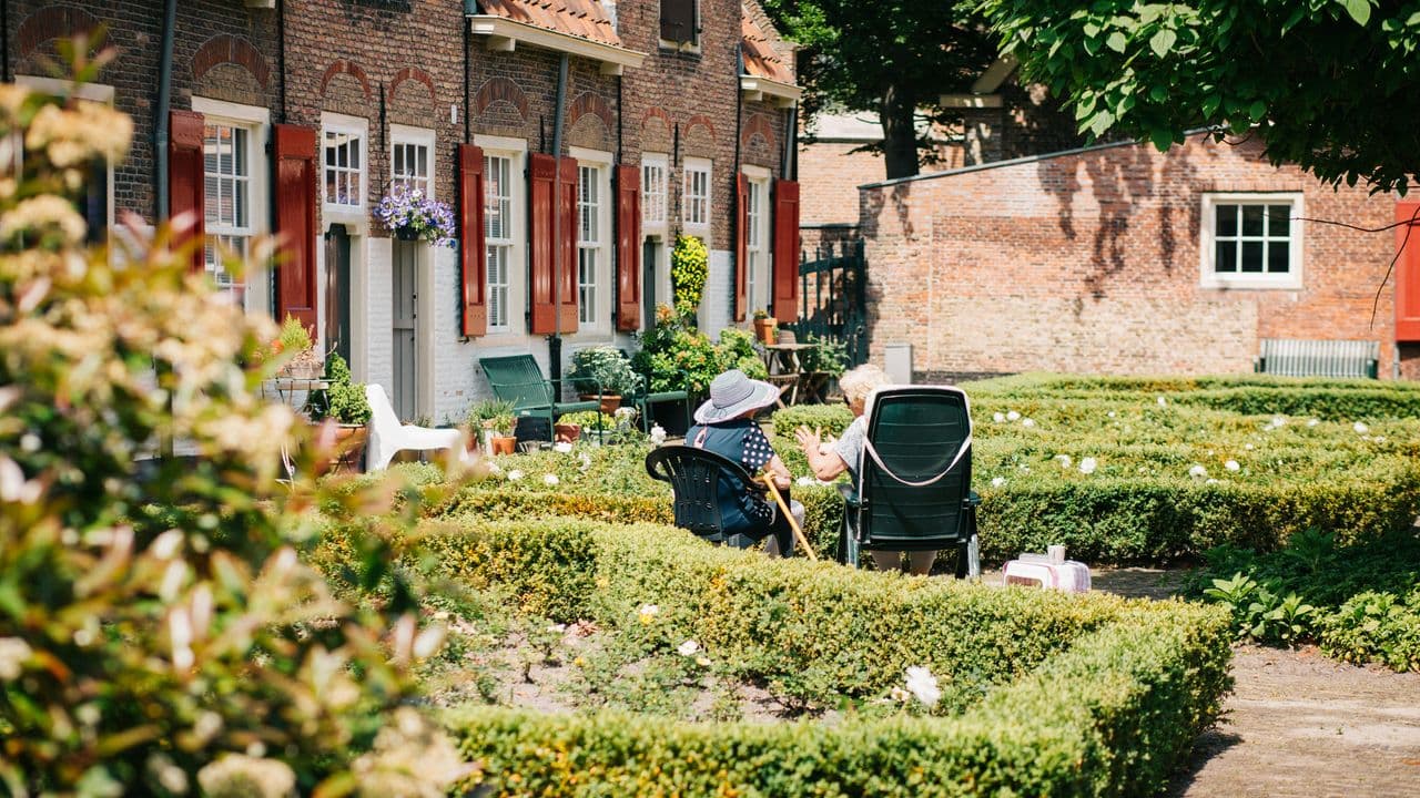 Dos personas mayores sentadas en sillas al sol en Naaldwijk