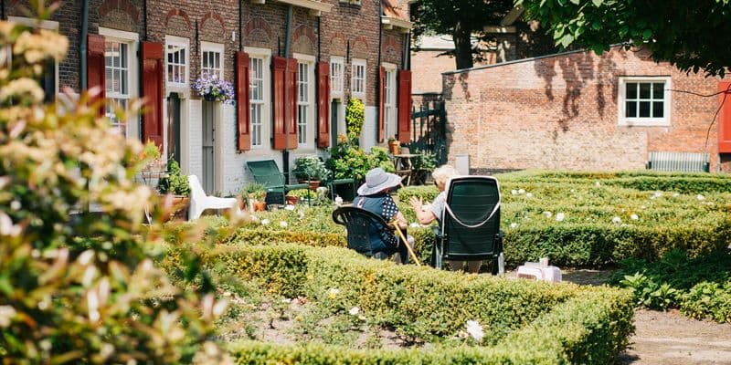 Dos personas mayores sentadas en sillas al sol en Naaldwijk