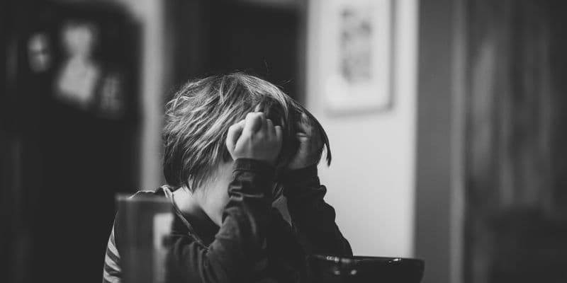 Niño con las manos en la cabeza