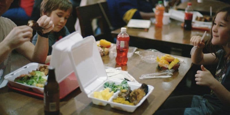 niños en una cafetería escolar recibiendo comidas gratuitas.