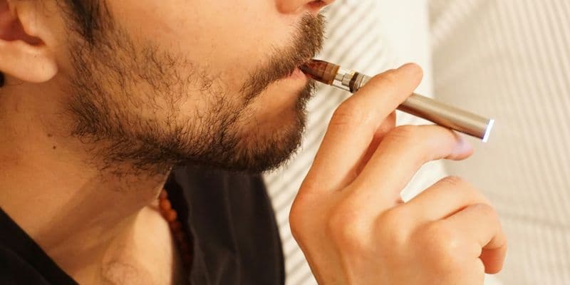 Persona fumando un cigarro electrónico