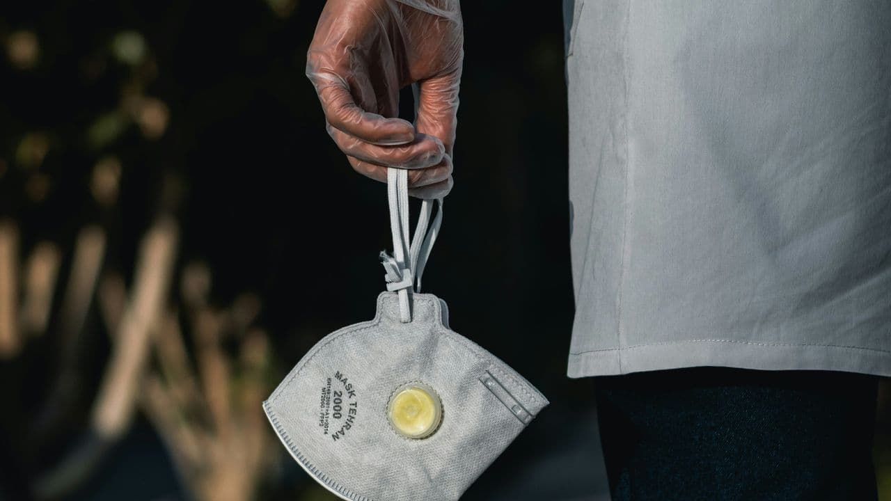 Persona con mascarilla en la mano