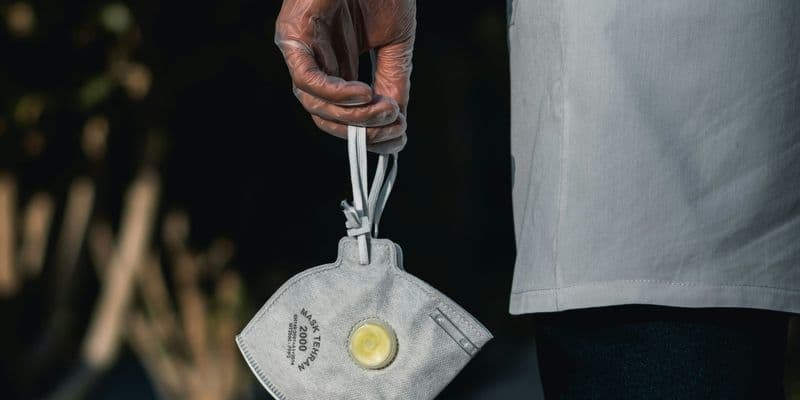 Persona con mascarilla en la mano