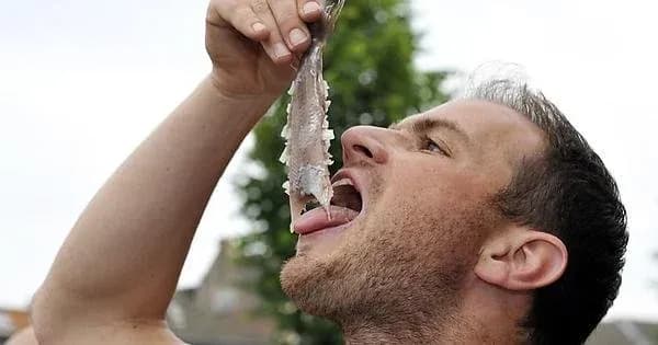 Hombre comiendo arenque holandés