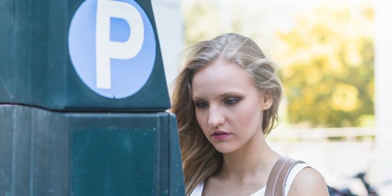Mujer pagando en un parquímetro