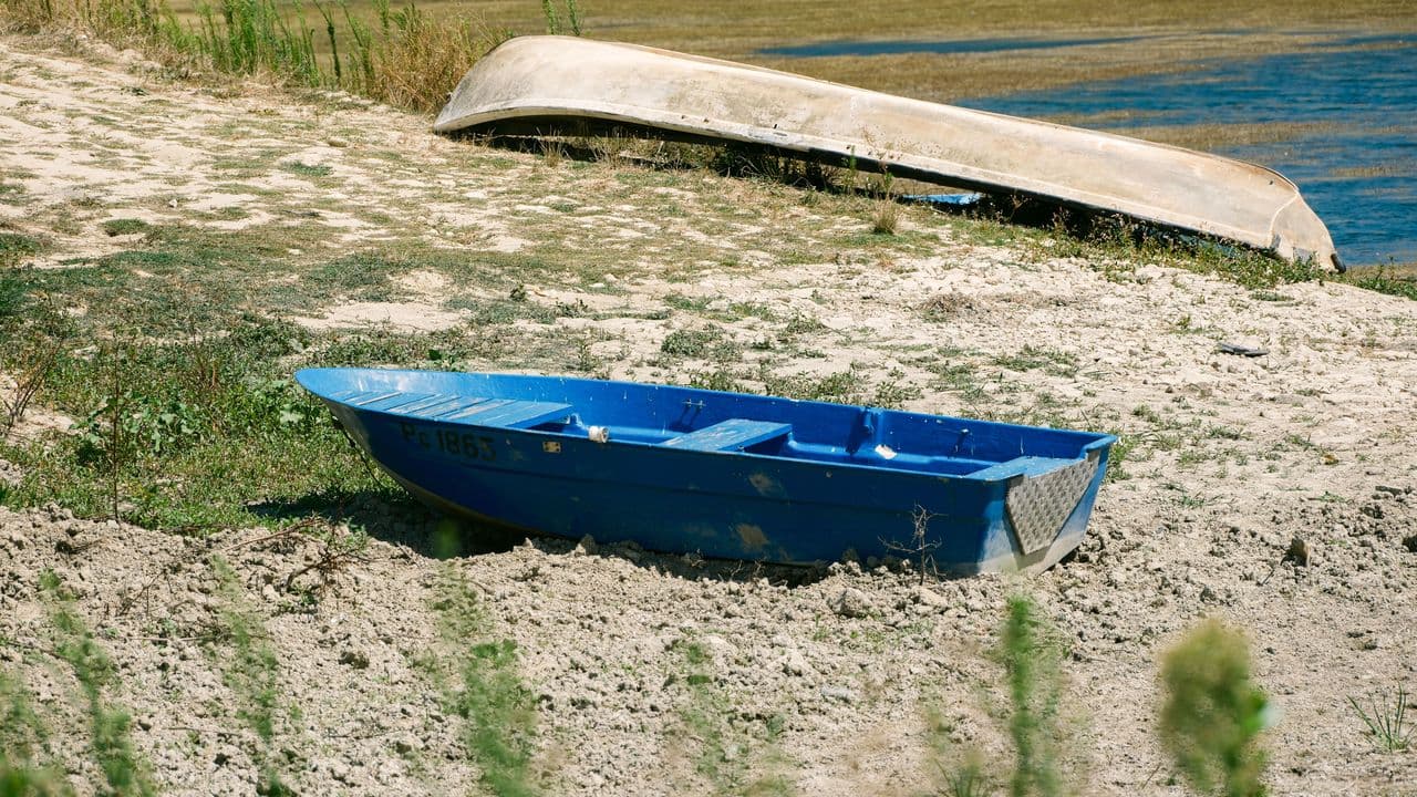 Barca en un río seco durante una sequía de verano