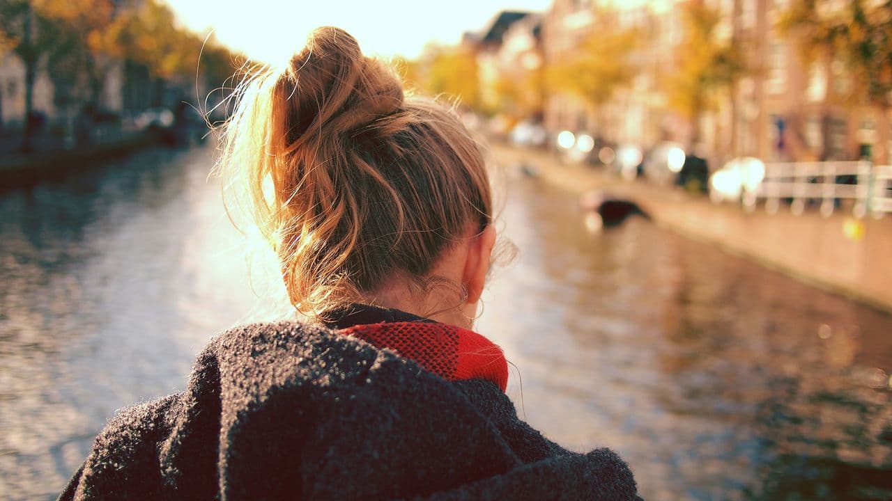 Mujer de espaldas enfrente de un canal